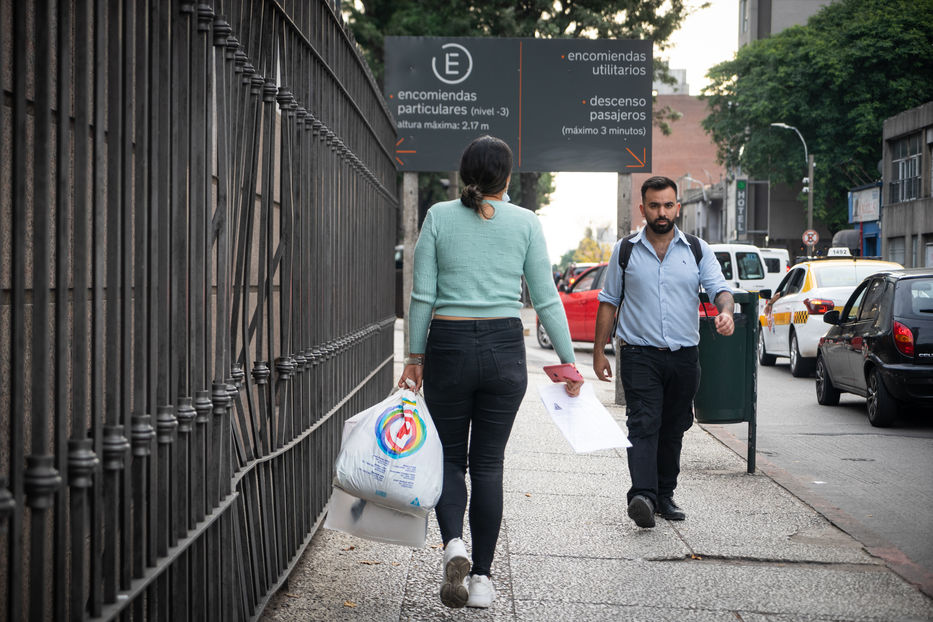 Noheli lleva una copia de su CV en una mano y bolsas con ropa que recibió por parte de Manos Veneguayas. Foto: Sebastián Astorga | Montevideo Portal