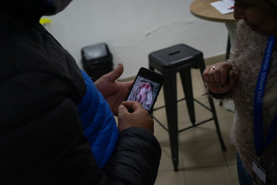 Ender le muestra  a Pantoja una fotografía en su celular de su hija recién nacida. Foto: Sebastián Astorga | Montevideo Portal