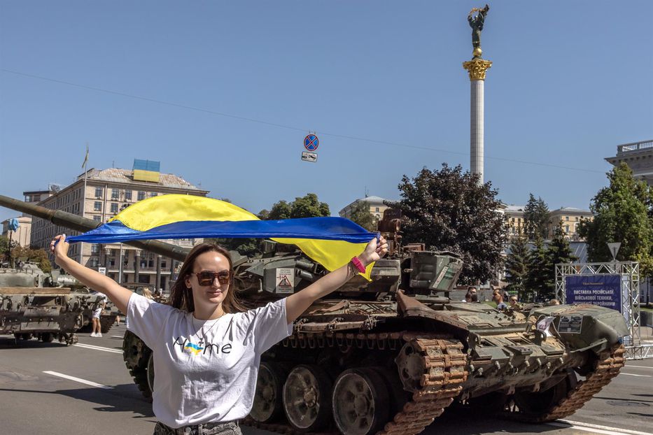 Joven portando la bandera de Ucrania junto a un vehículo militar ruso capturado y presentado en la calle Khreshchatyk, en el centro de Kiev. - Foto: EFE/EPA/ROMAN PILIPEY