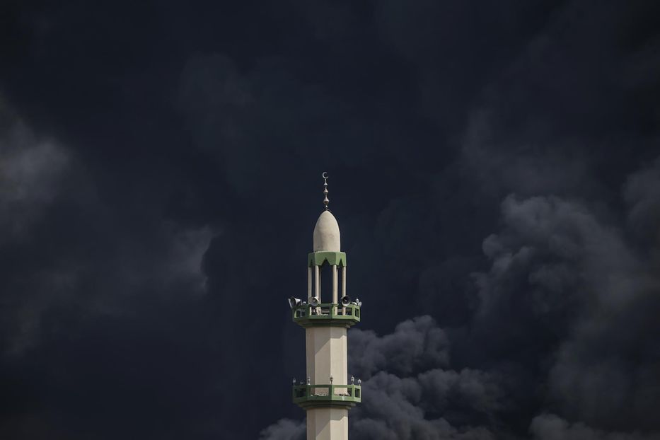 El humo se eleva detrás del minarete de una mezquita tras un ataque aéreo israelí en el barrio de Al-Tufah, en la ciudad de Gaza, este 11 de octubre. Foto: Mohammed Saber / EFE