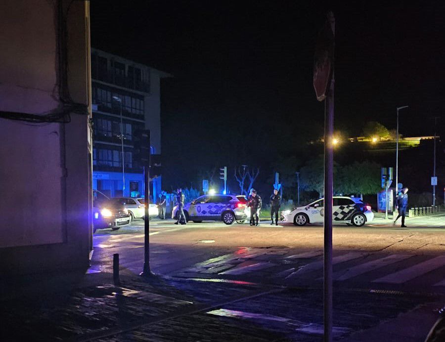 Patrulleros de la Policía Local gallega y la Policía Nacional española demoran a un auto en medio del apagón; de fondo, las luces del palacio presidencial de Monte Pío. Foto: Federico Pereira