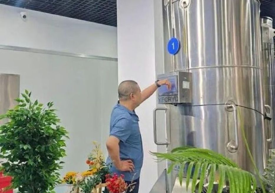 Gui junto a la cápsula que contiene a su esposa.  Foto: Infzm.com