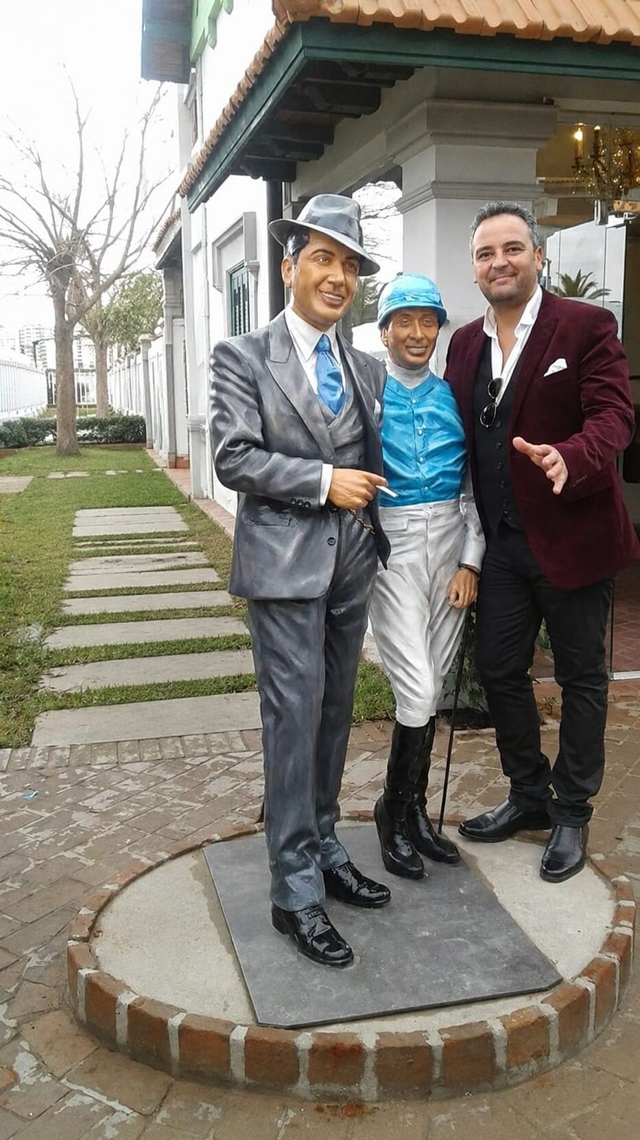 Alberto Saravia junto a las esculturas de Gardel y Leguizamo.