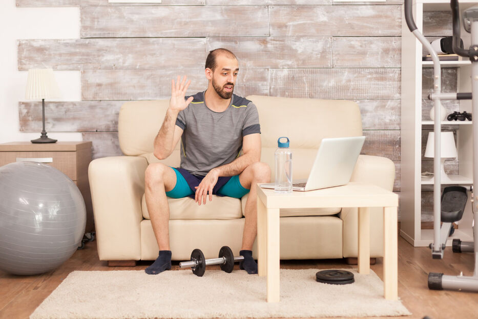 Hombre sentado en el sillón con ropa deportiva. Foto: Freepik